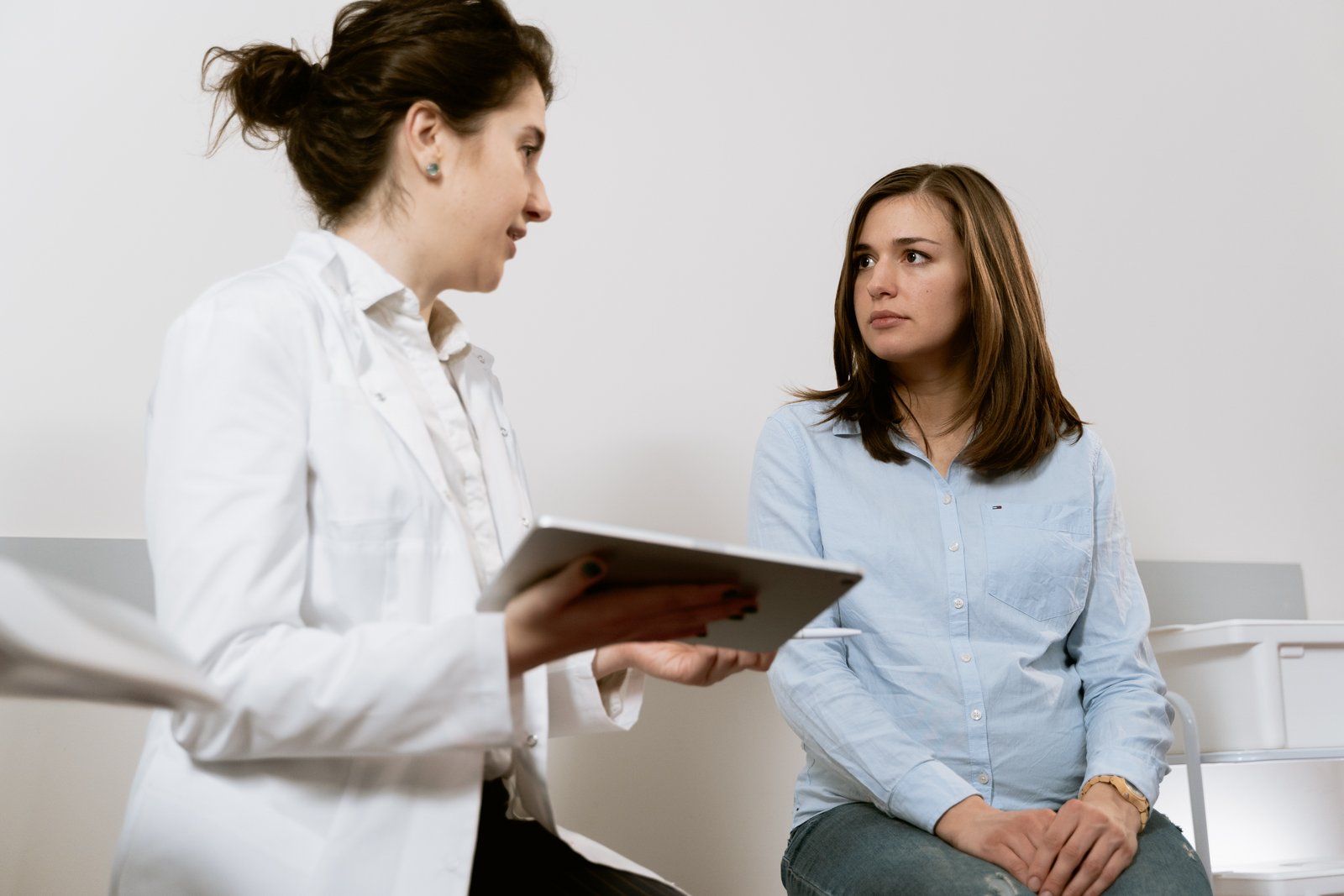 En kvinne sitter hos gynekologen og snakker med henne