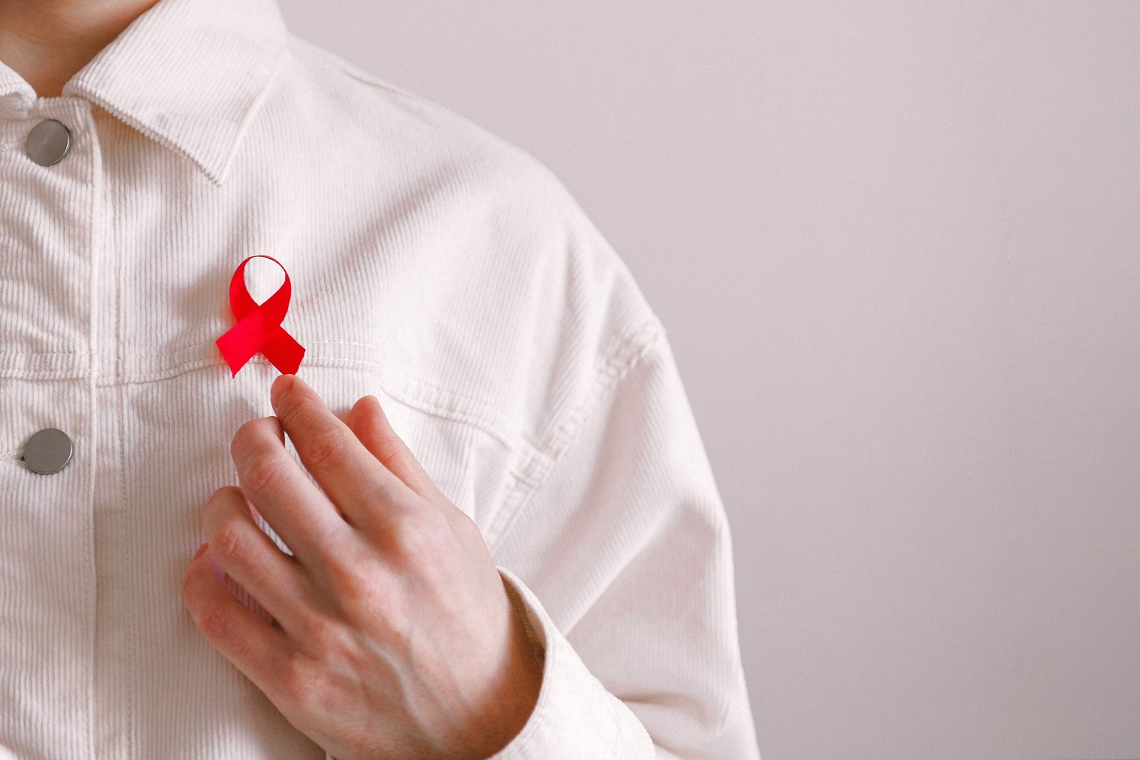 Mann med rød sløyfe på skjorten på Verdens AIDS-dag